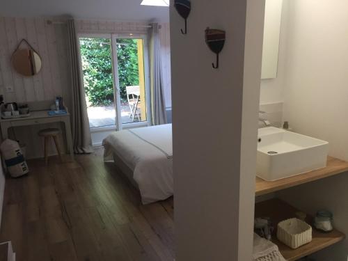 une chambre avec un lit, une baignoire et un lavabo dans l'établissement Maison l'heure bleue, à Lanton