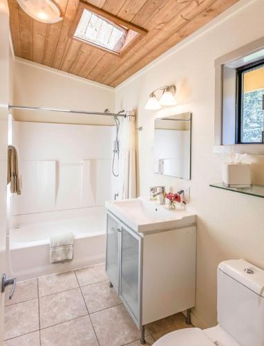 a bathroom with a sink and a tub and a toilet at Cottages at Little River Cove in Little River