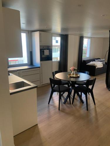 a kitchen and a table and chairs in a room at book2stay - Apartments Herisau in Herisau