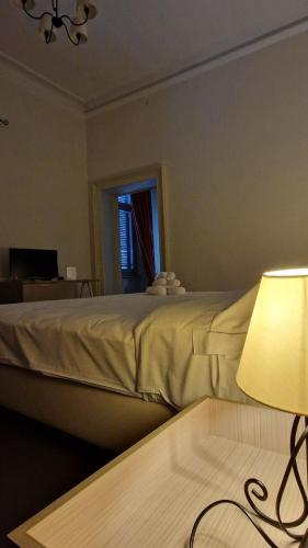 a bedroom with a bed with a lamp and a window at Villa Cavalleri in Gattinara