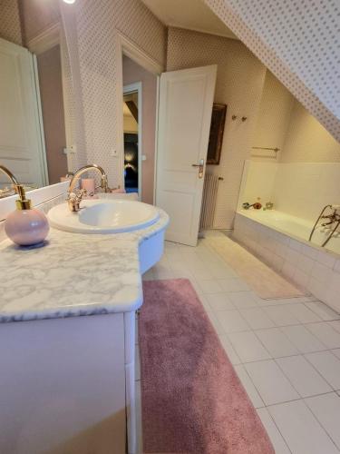 une salle de bain avec un lavabo et une baignoire dans l'établissement Villa Bovary Deauville, exceptional location, à Deauville