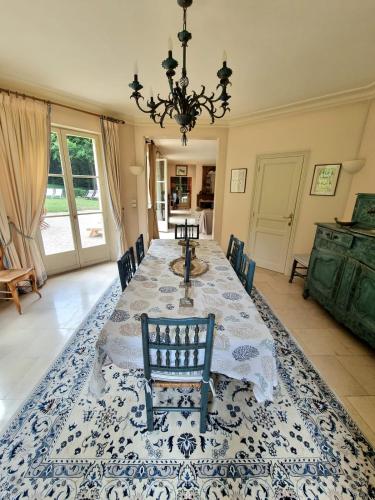 une salle à manger avec une table et un lustre dans l'établissement Villa Bovary Deauville, exceptional location, à Deauville