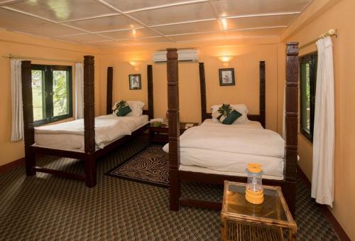 una camera d'albergo con due letti e un tavolo di Maruni Resort Pvt Ltd a Tikoli