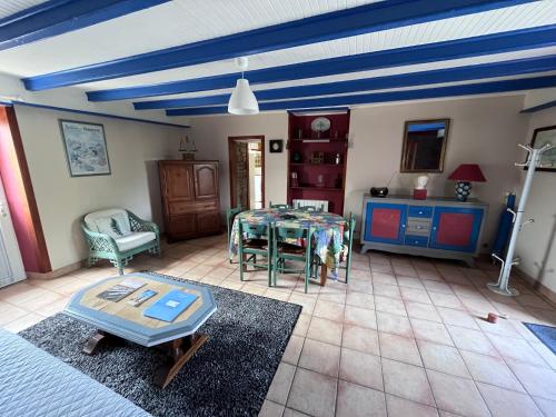 un salon avec une table et un plafond bleu dans l'établissement Les Gîtes d'Amis, à Guérande