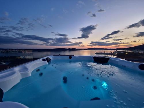 a hot tub with a sunset in the background at Villa Oasis in Trogir