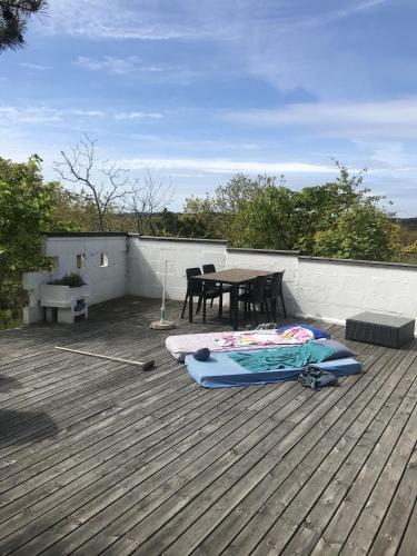 a bed on a deck with a table on a roof at Cozy 11 beds Cabin Retreat in Hvaler, Norway in Rød