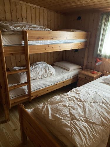 a bedroom with two bunk beds in a cabin at Cozy 11 beds Cabin Retreat in Hvaler, Norway in Rød