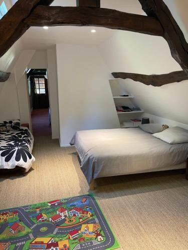 - une chambre avec 2 lits et un tapis au sol dans l'établissement Maison Juliette, à Auzouville-sur-Saâne