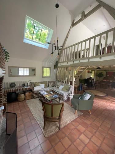 un grand salon avec des canapés et une table dans l'établissement Maison Juliette, à Auzouville-sur-Saâne