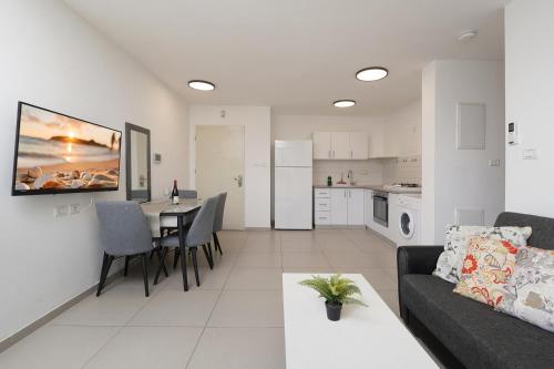 a living room and kitchen with a couch and a table at Levication Multiple Apartments - Family Stays Tiberias in Tiberias