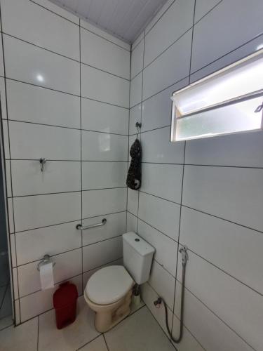 a small bathroom with a toilet and a light at Chácara Cantinho dos Sonhos in Chapada dos Guimarães