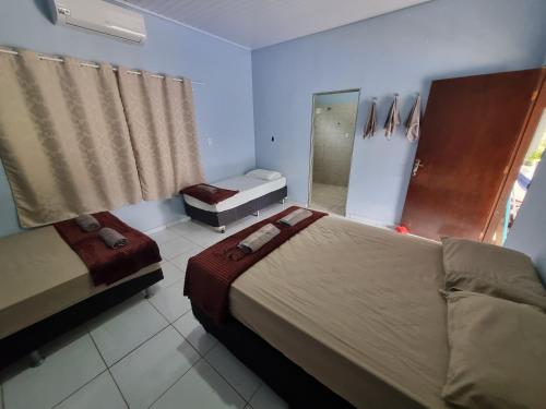 a bedroom with two beds and a mirror and a window at Chácara Cantinho dos Sonhos in Chapada dos Guimarães