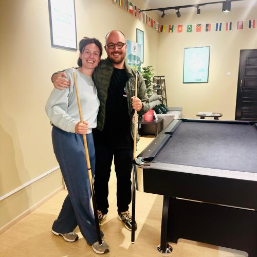 a man and a woman standing next to a pool table at A3A Oastel CoLiving in Tanah Rata