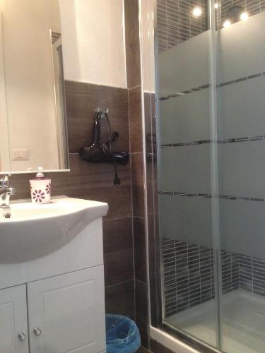 a bathroom with a glass shower and a sink at B&B Maison Rosetta IUN-E4948 in Nuoro