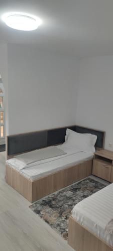 a large bed in a room with a white wall at Căsuța Bunicilor in Dorna Cîndrenilor