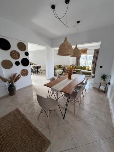 a dining room and living room with a table and chairs at Jojo's Home in Kamiros