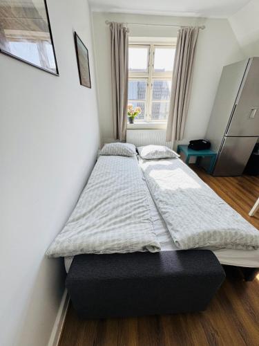 a twin bed in a room with a window at Casa de Rainer Copenhagen Room 7 in Copenhagen
