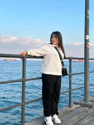 a woman standing on a pier next to the water at Benin city in Mama