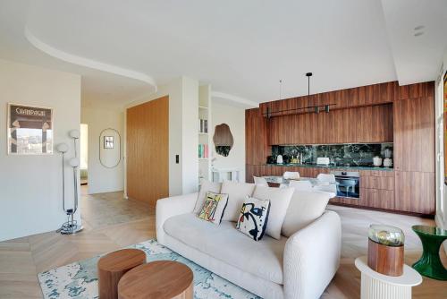 un salon avec un canapé blanc et une cuisine dans l'établissement Riverside Chic Loft, à Boulogne-Billancourt