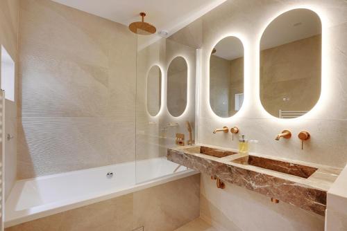 La salle de bains est pourvue de 3 miroirs et d'une douche. dans l'établissement Riverside Chic Loft, à Boulogne-Billancourt