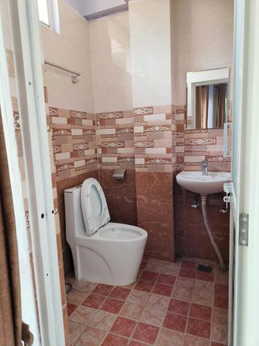 a bathroom with a toilet and a sink at Hotel sunrise heaven in Pokhara