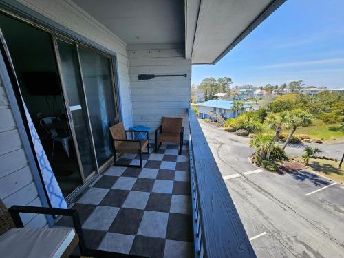 a porch with a checkered floor on a house at BEACHSIDE CONDO-WATER AND POOL VIEW Top Floor in Tybee Island