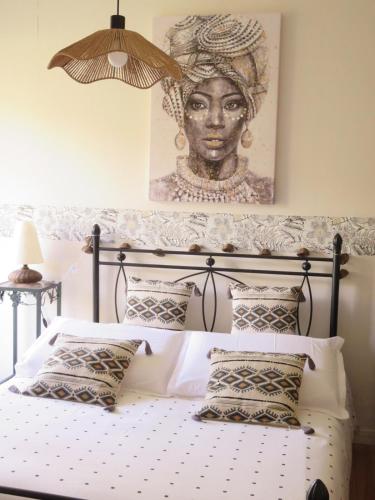 - une chambre avec un lit et un portrait d'une femme dans l'établissement l'ostalet, à Arette