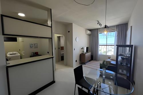 a room with a glass table and a living room at Flat centro de Londrina - Vista incrível in Londrina