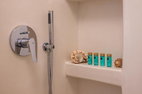 a bathroom with a shower and a shelf with toiletries at Kastraki Riviera in Kastraki Naxou
