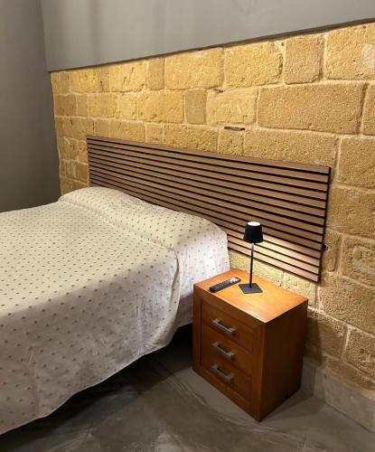 a bedroom with a bed and a brick wall at La Terrazza in Marsala