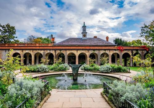 a garden with a fountain in front of a building at Anwar House in London
