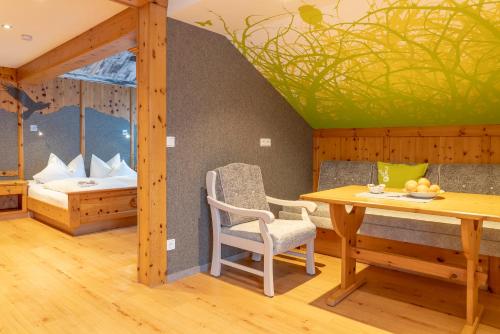 a dining room with a table and a bed at Ferienwohnung Ferienglück in Krün