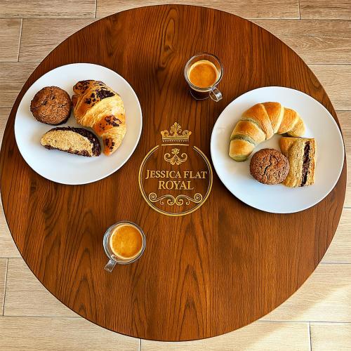 a wooden table with two plates of pastries and coffee at Jessica Flat Malta Royal Guesthouse in Cospicua