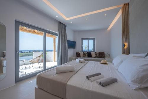 a bedroom with a large bed and a large window at Kastraki Riviera in Kastraki Naxou