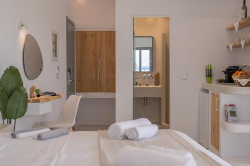 a bathroom with towels on a bed and a sink at Kastraki Riviera in Kastraki Naxou