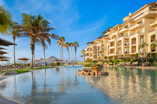 a pool at a resort with palm trees and buildings at Villa la Estancia Beach Resort & Spa in Cabo San Lucas