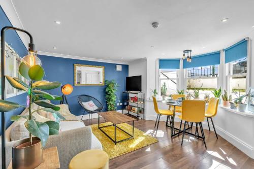 a living room with a couch and a table with chairs at Seaside Gem Apartment By My Getaways in Brighton & Hove