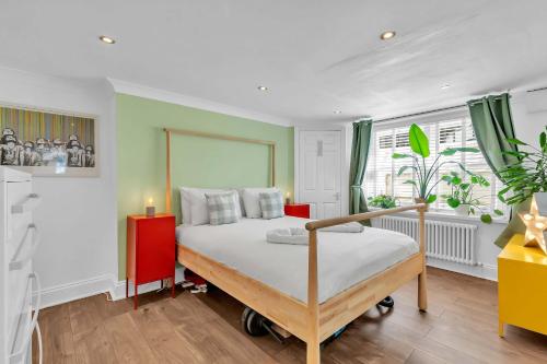 a bedroom with a large bed and a red cabinet at Seaside Gem Apartment By My Getaways in Brighton & Hove