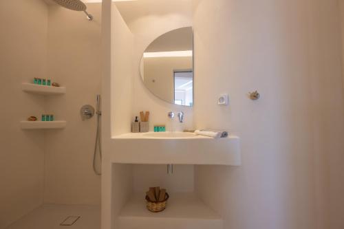 a white bathroom with a sink and a mirror at Kastraki Riviera in Kastraki Naxou