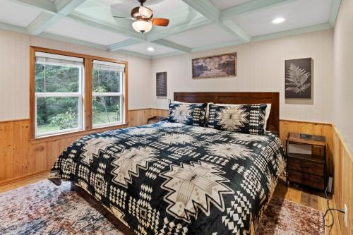 a bedroom with a bed and a ceiling fan at Cedar Cabin at Rainier Entrance-Hot Tub and Cinema in Ashford