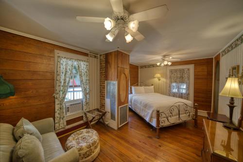 a bedroom with a bed and a ceiling fan at Downtown Magnolia Ste Piedmont in Eureka Springs