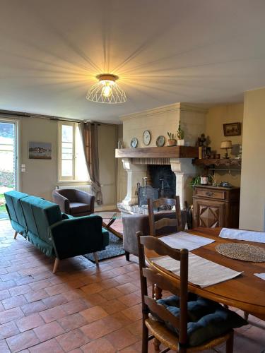 un salon avec une table et une cheminée dans l'établissement la sifflerie, à Manerbe