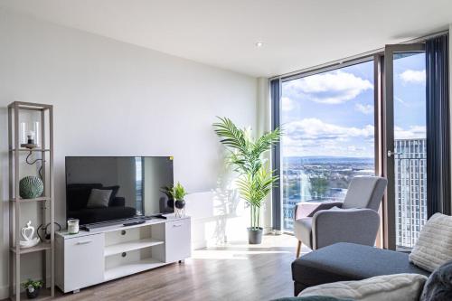 a living room with a tv and a large window at Manchester City Centre,Picadilly , Skyline View in Manchester