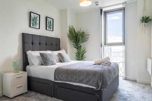 a bedroom with a large bed and a window at Manchester City Centre,Picadilly , Skyline View in Manchester
