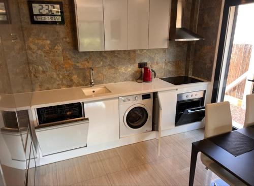 een keuken met een wasmachine en een wastafel bij La Zenia12 in Orihuela