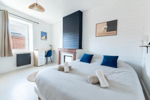 a bedroom with a large white bed with blue pillows at Le Nautique in Valence