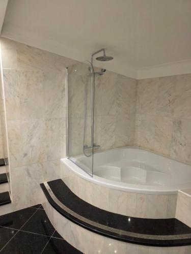 a bathroom with a bath tub with a shower at Vila Luz in Vilamoura