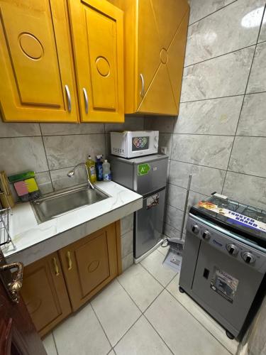 Una pequeña cocina con fregadero y estufa. en Bliss Home Residence, en Douala