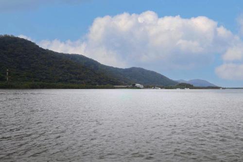 a large body of water with mountains in the background at Apto com lazer completo a 500m da Praia da Enseada in Bertioga