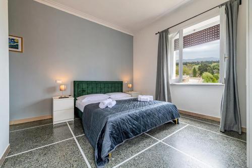 Un dormitorio con una cama y una ventana grande. en Amor Rome Apartments - 6 posti letto e 2 bagni a 4 fermate dal COLOSSEO, en Roma